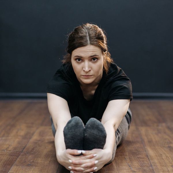 Woman in a calming yoga pose focusing on spinal alignment.